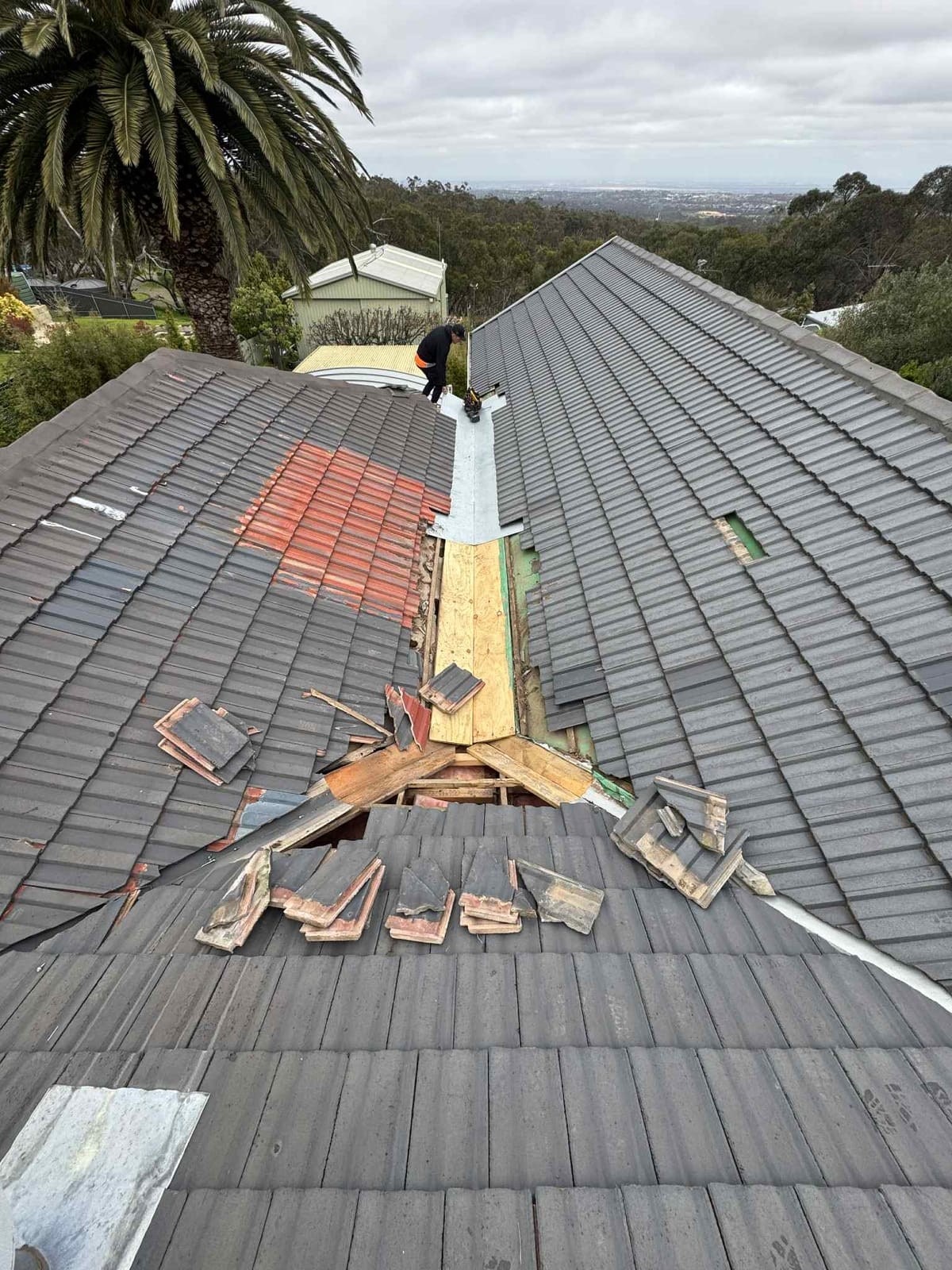 A tiled roof under repair, with the ridge opened up.