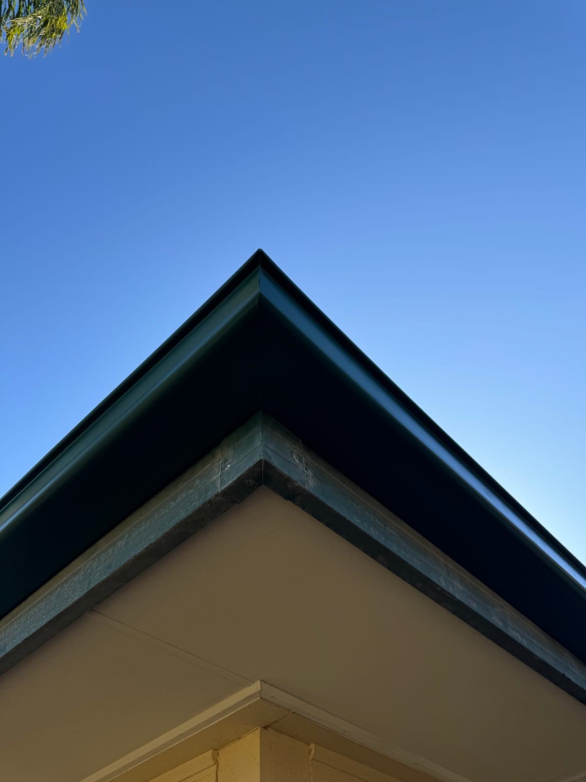 A finished roof edge against a blue sky.
