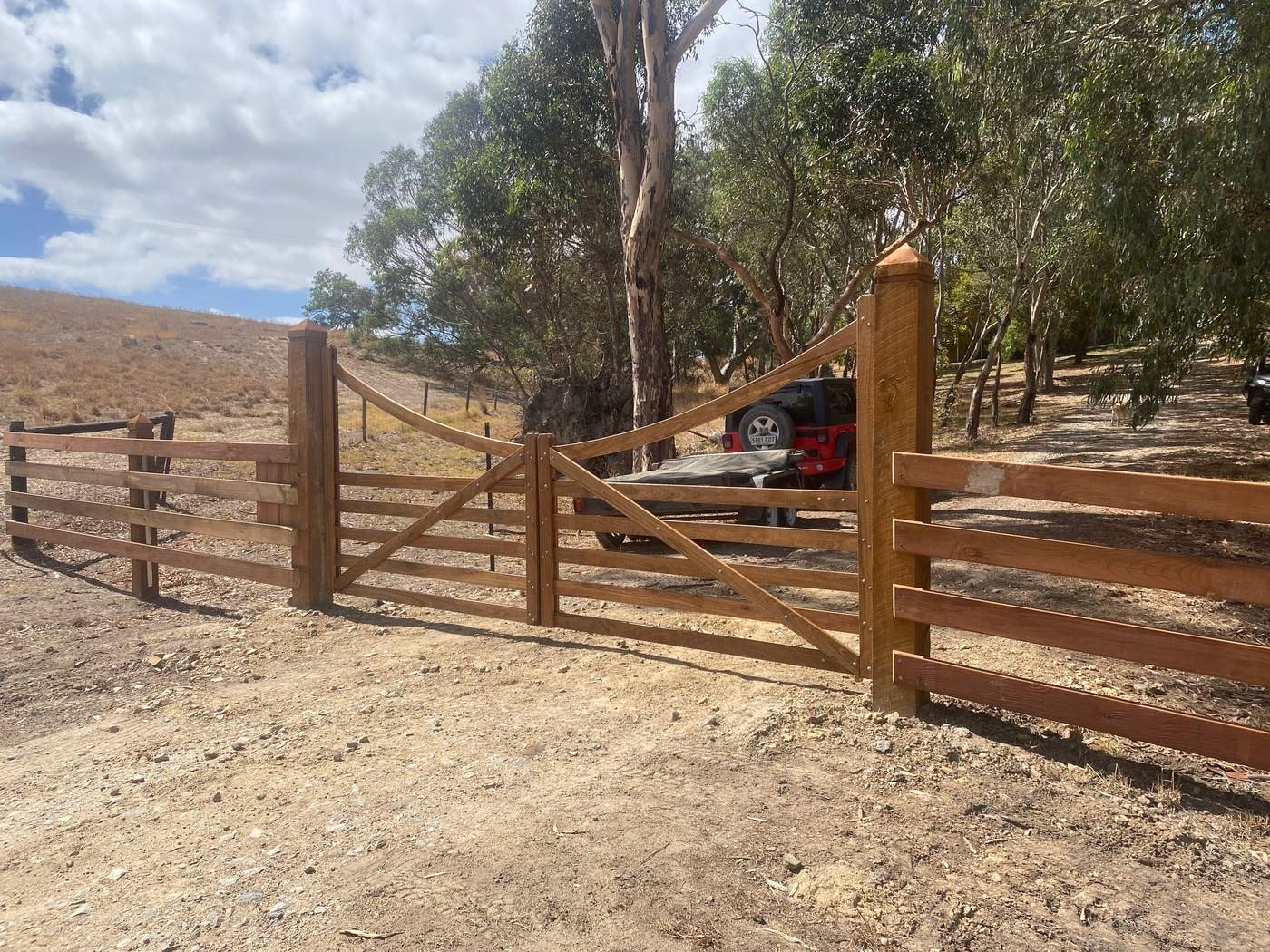 Curved-top gates with post and rail fencing.
