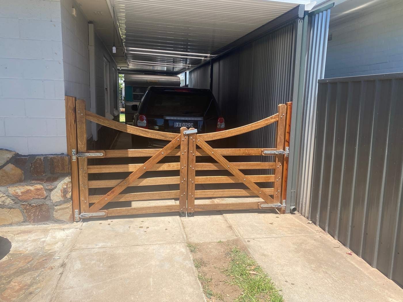 A curved-top gate pair near a shed.