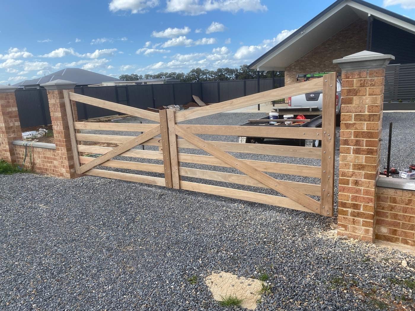 Double timber gates between brick pillars.