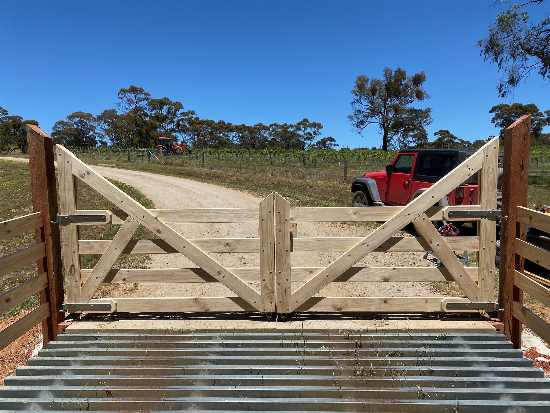 A timber farm gate by Aston Rural Enterprises over a cattle grid.