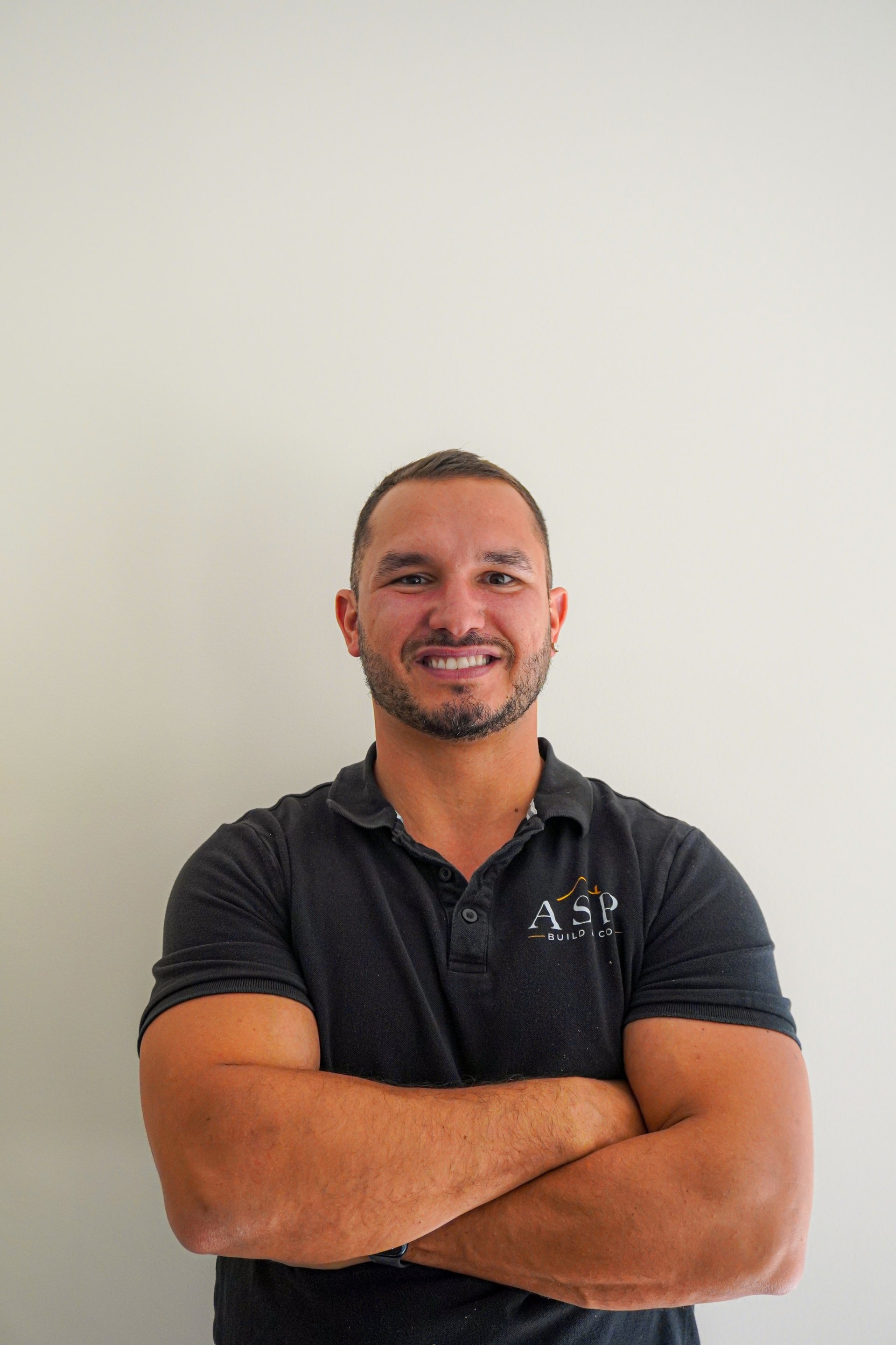 Anthony from ASP Build & Co, arms crossed, in an ASP polo.