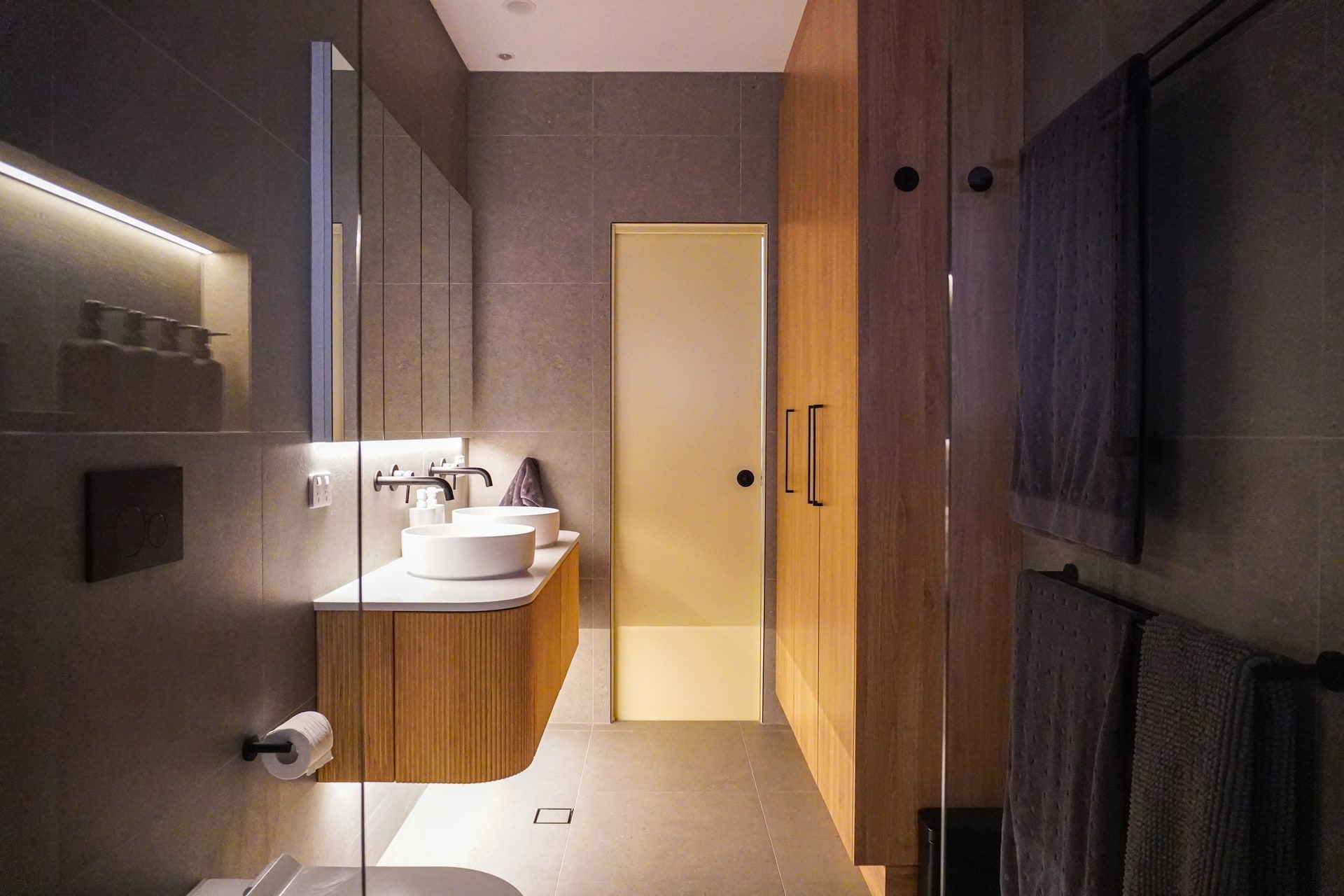 A finished Kingswood bathroom by ASP Build & Co with a floating timber vanity and LED niche.