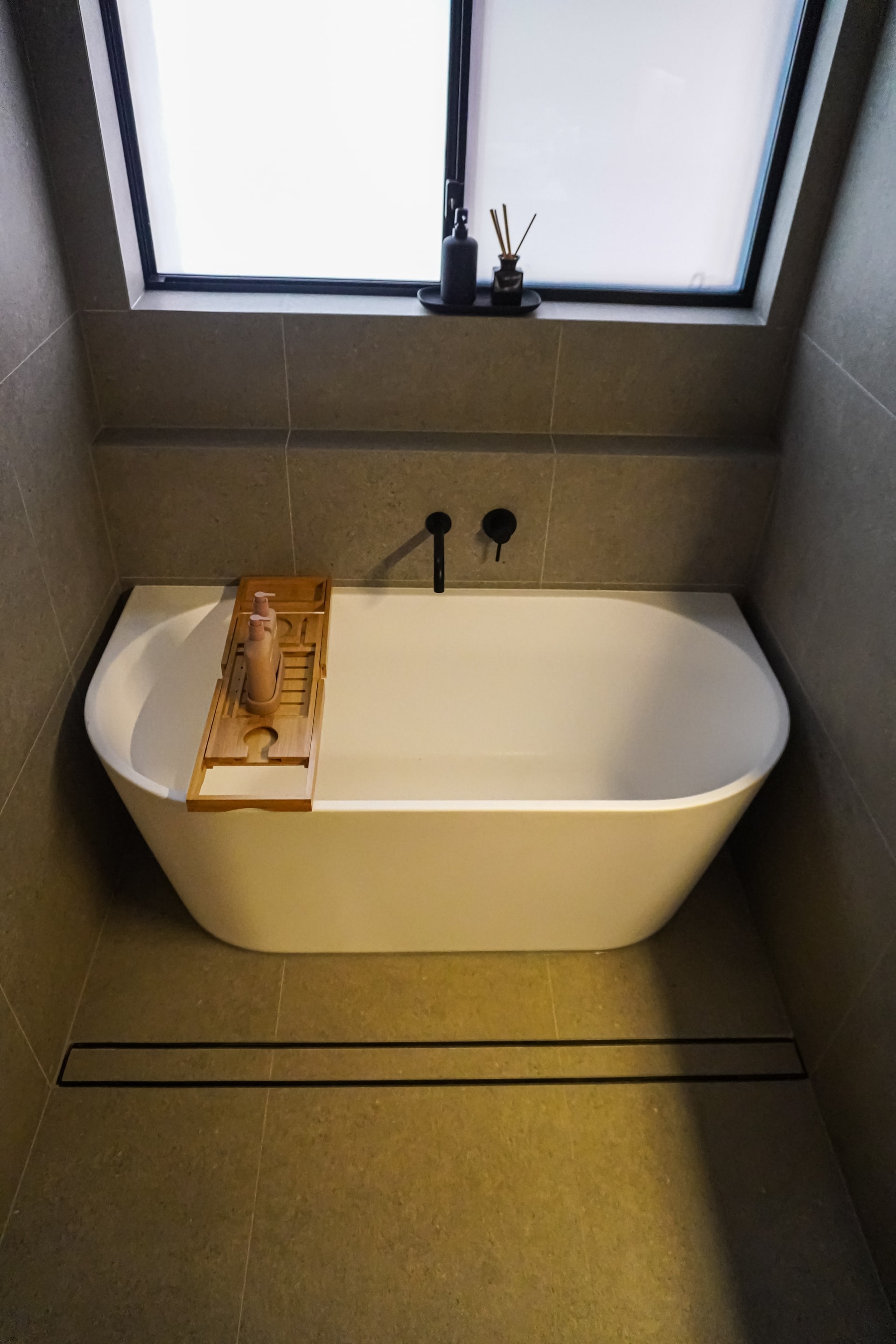 A freestanding bath under a skylight in a Kingswood bathroom.
