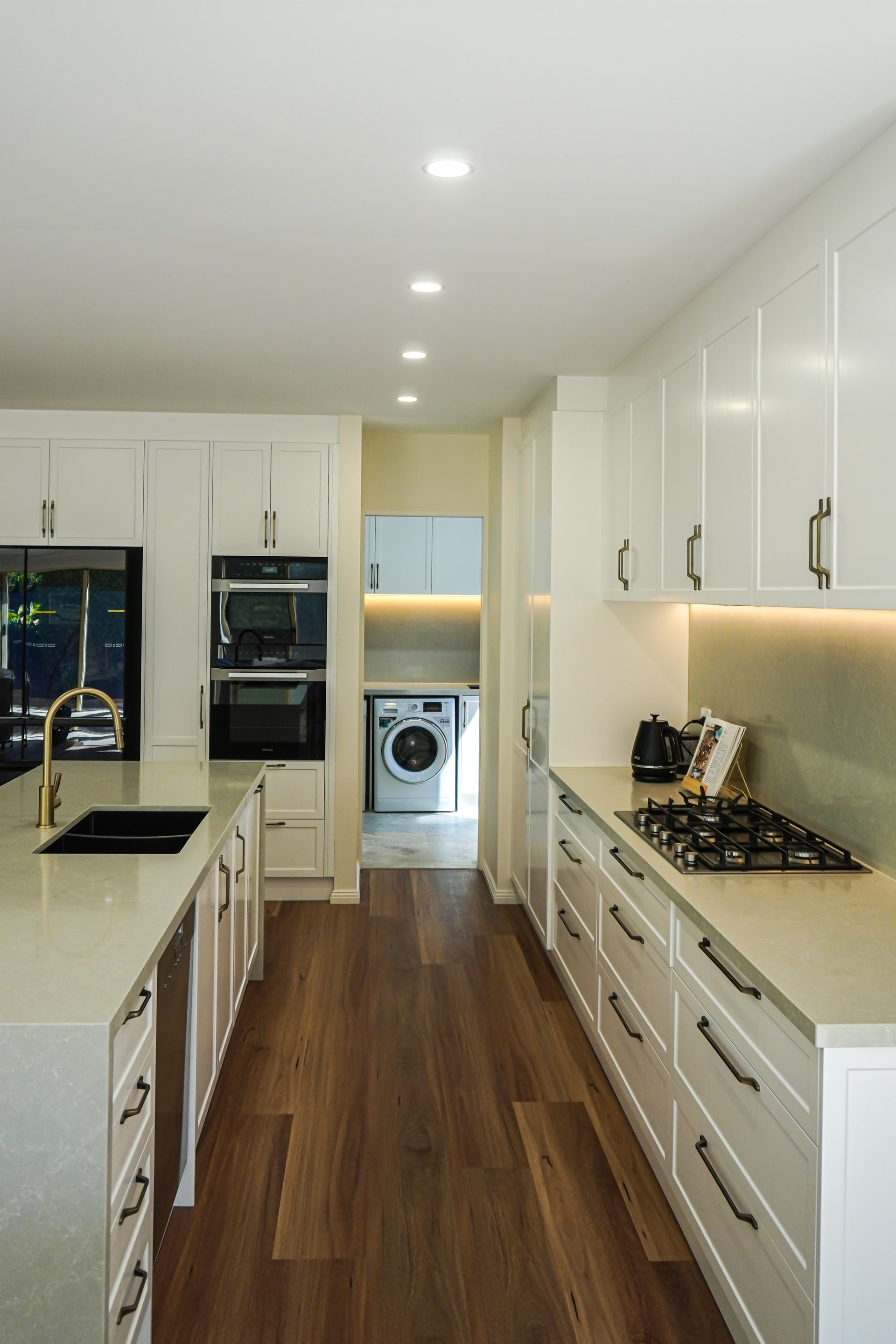 The Torrens Park kitchen galley with gas cooktop and laundry beyond.