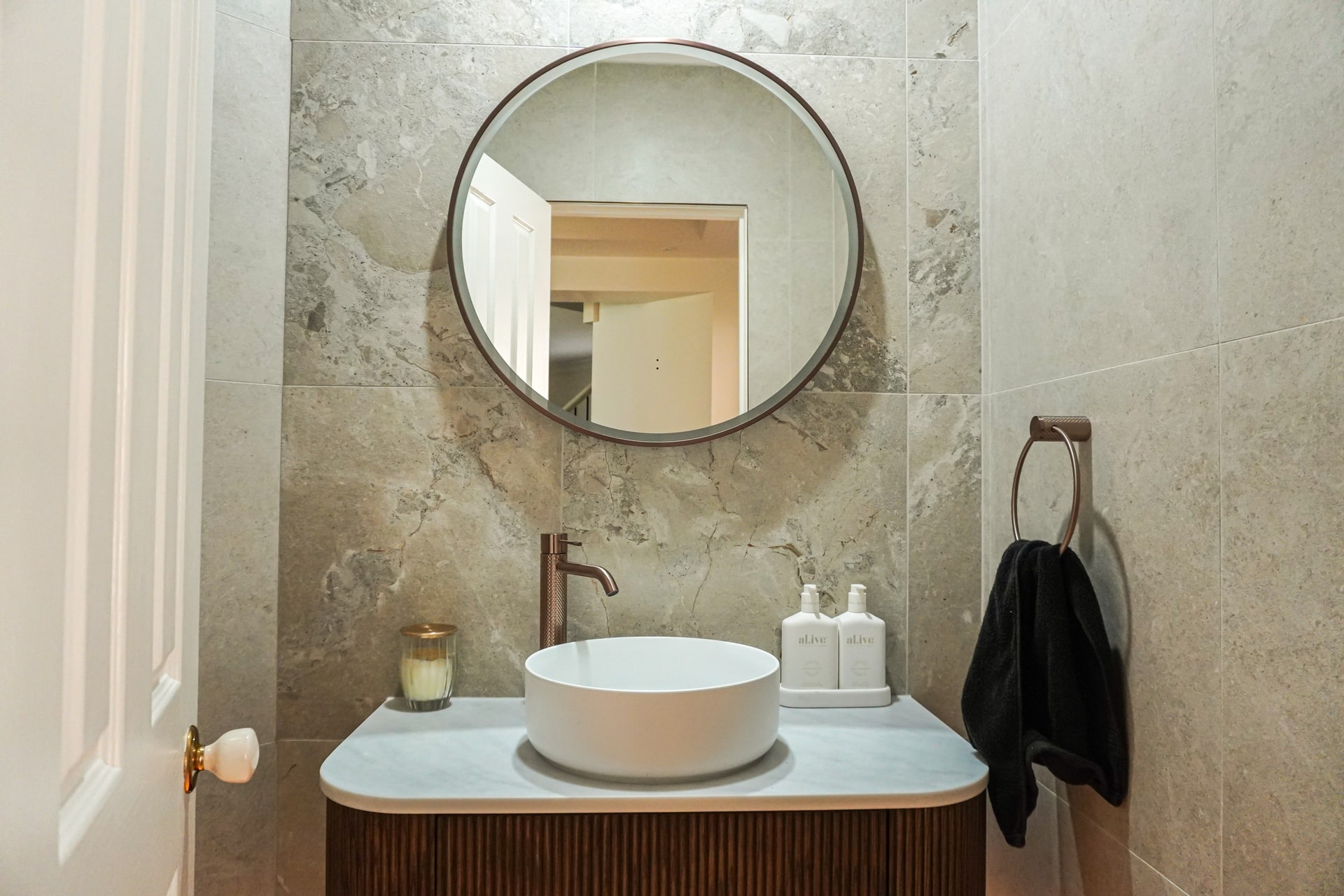 The Torrens Park powder room with a vessel basin and round mirror.