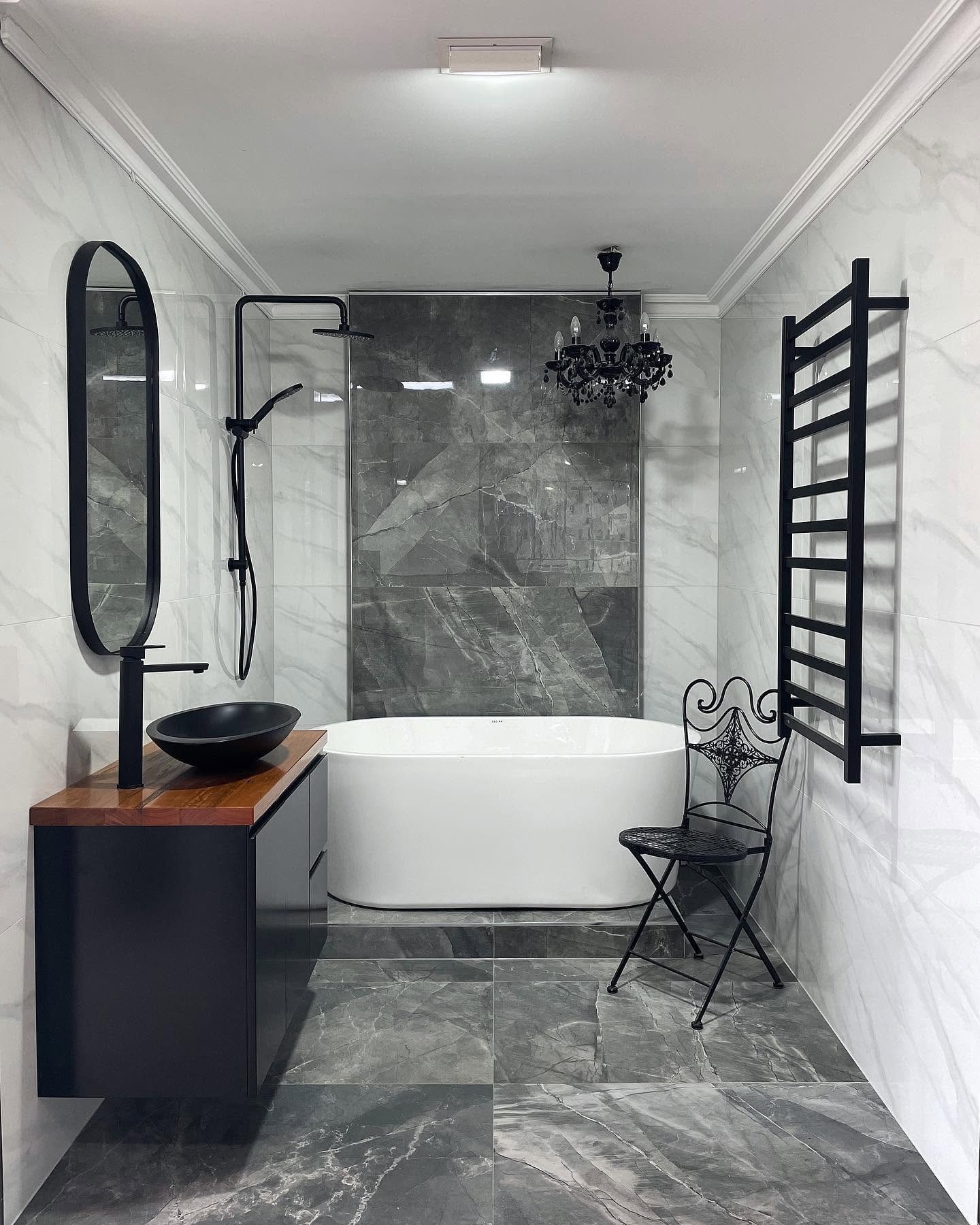 A finished Becks bathroom with marble-look tiles and a freestanding bath.