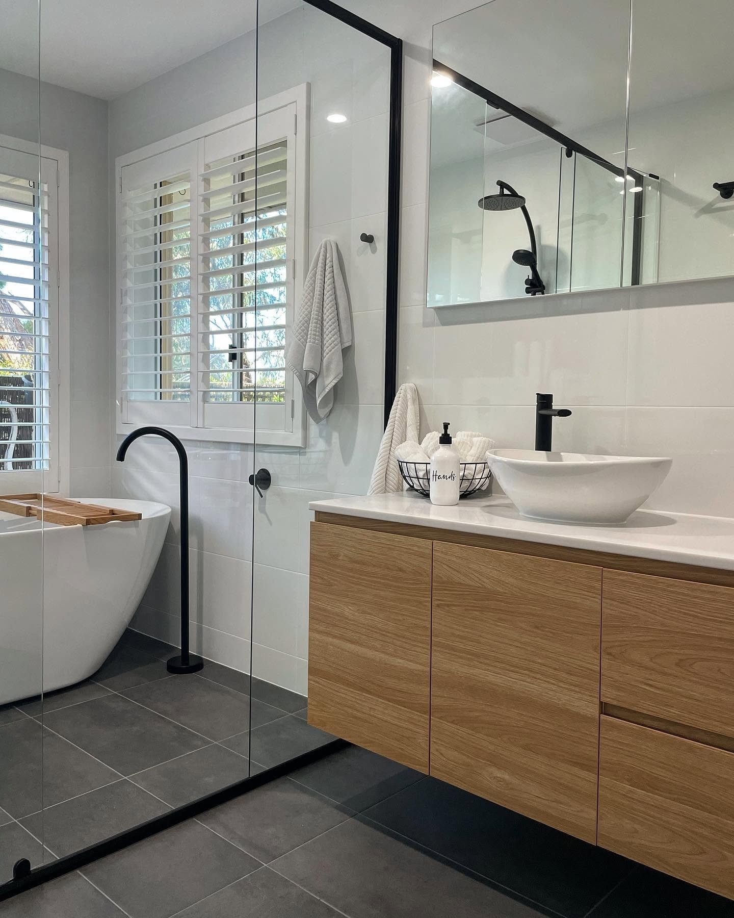 A Becks bathroom with a timber vanity and black frameless shower.