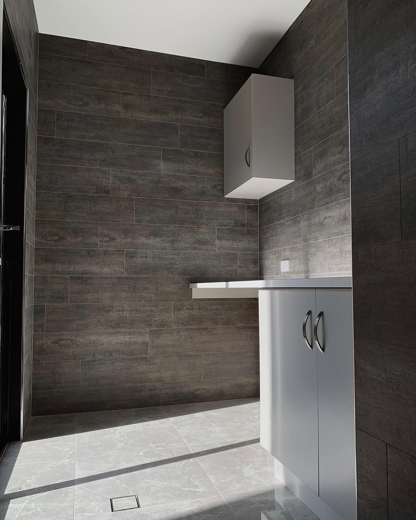 Dark timber-look wall tiling by Becks Bathrooms & Tiling.