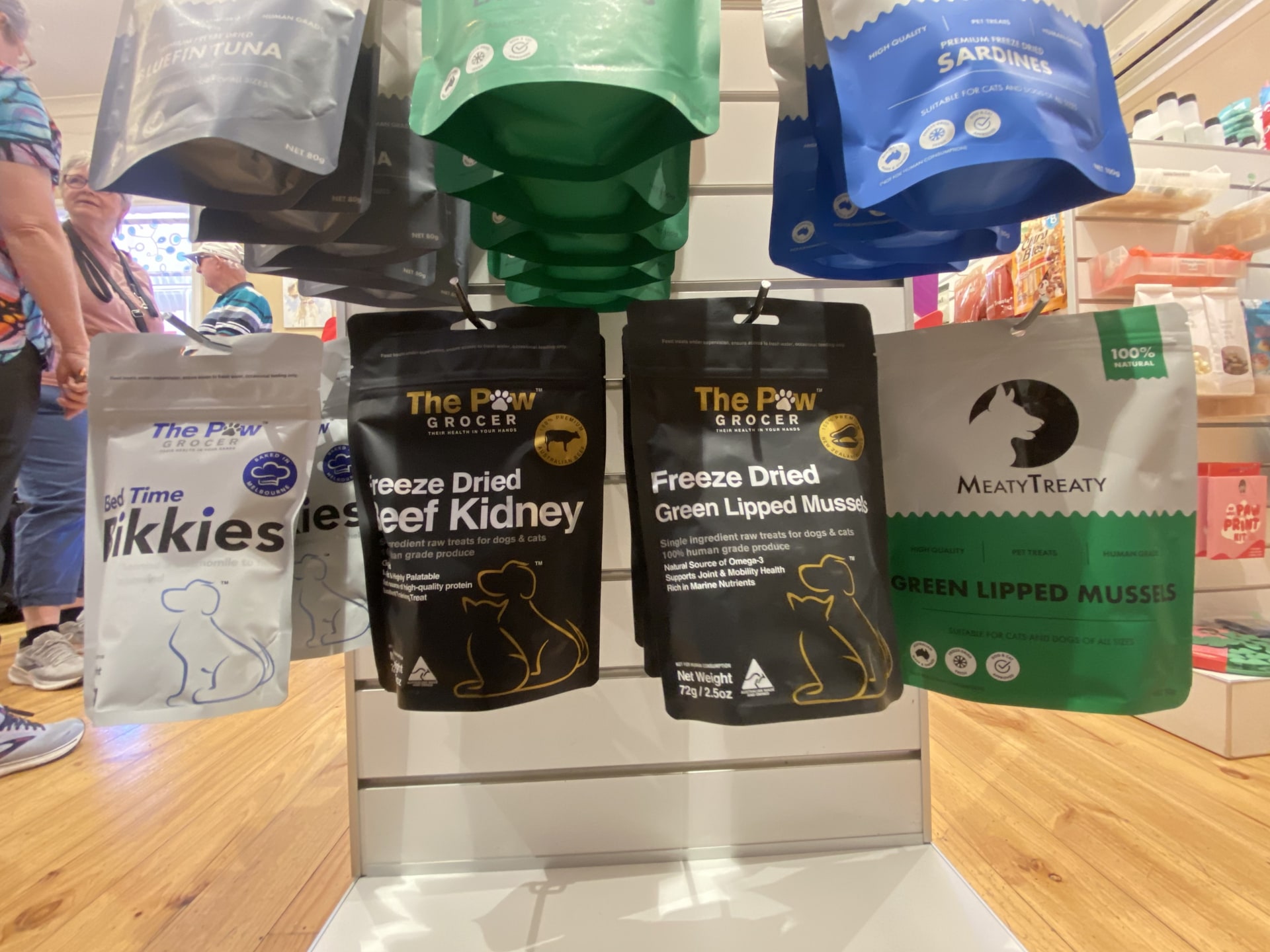Freeze-dried treats from The Paw Grocer and Meaty Treaty on a stand inside For Pets Sake.
