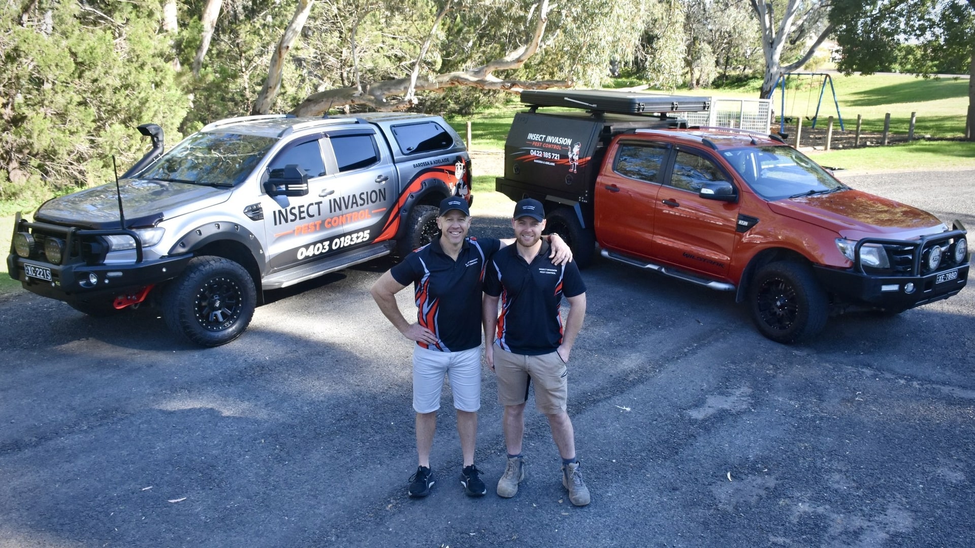 Garry and Josh Pape of Insect Invasion standing in front of their two branded utes.