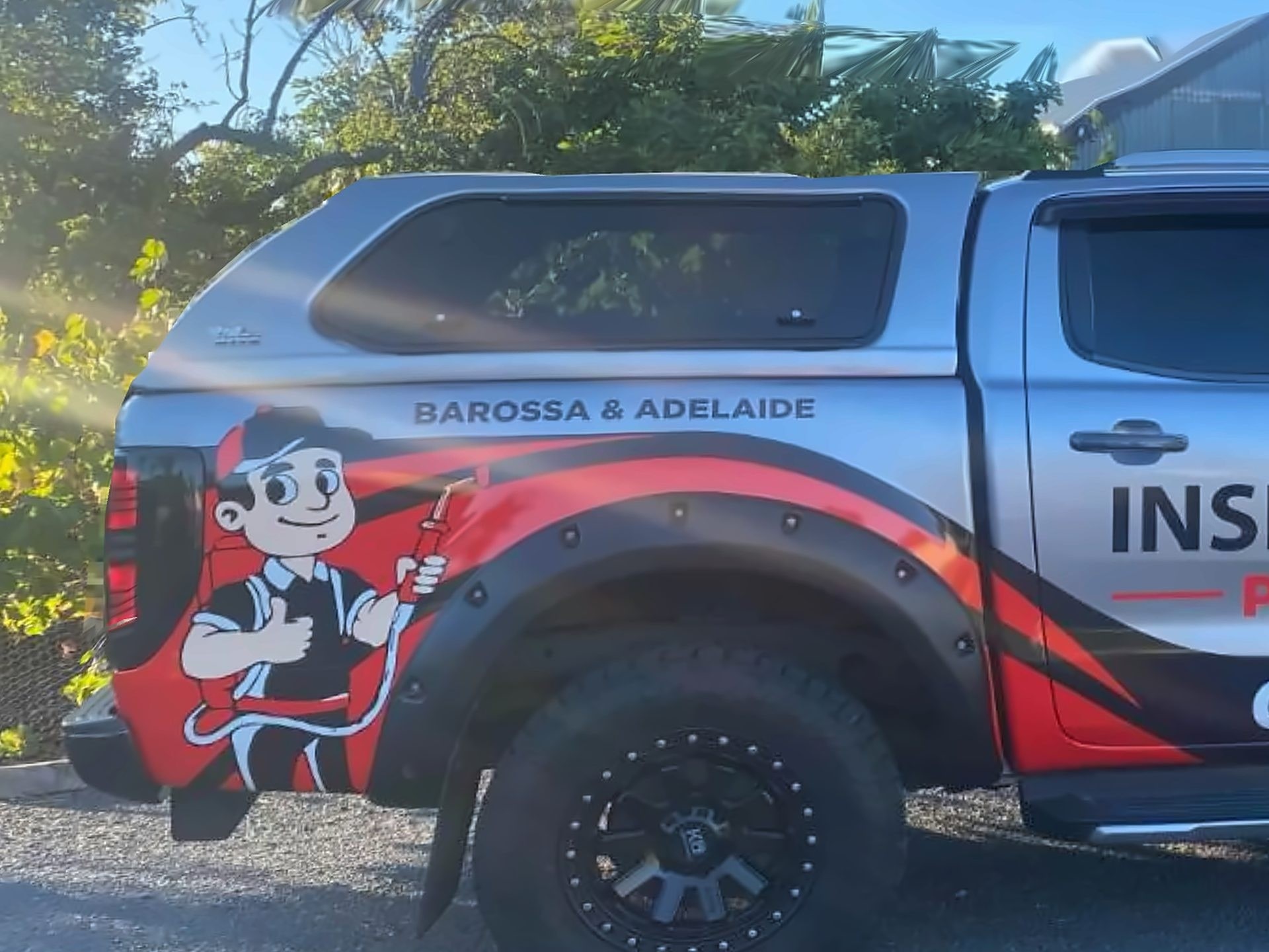 The Insect Invasion mascot and livery on the side of the silver ute.