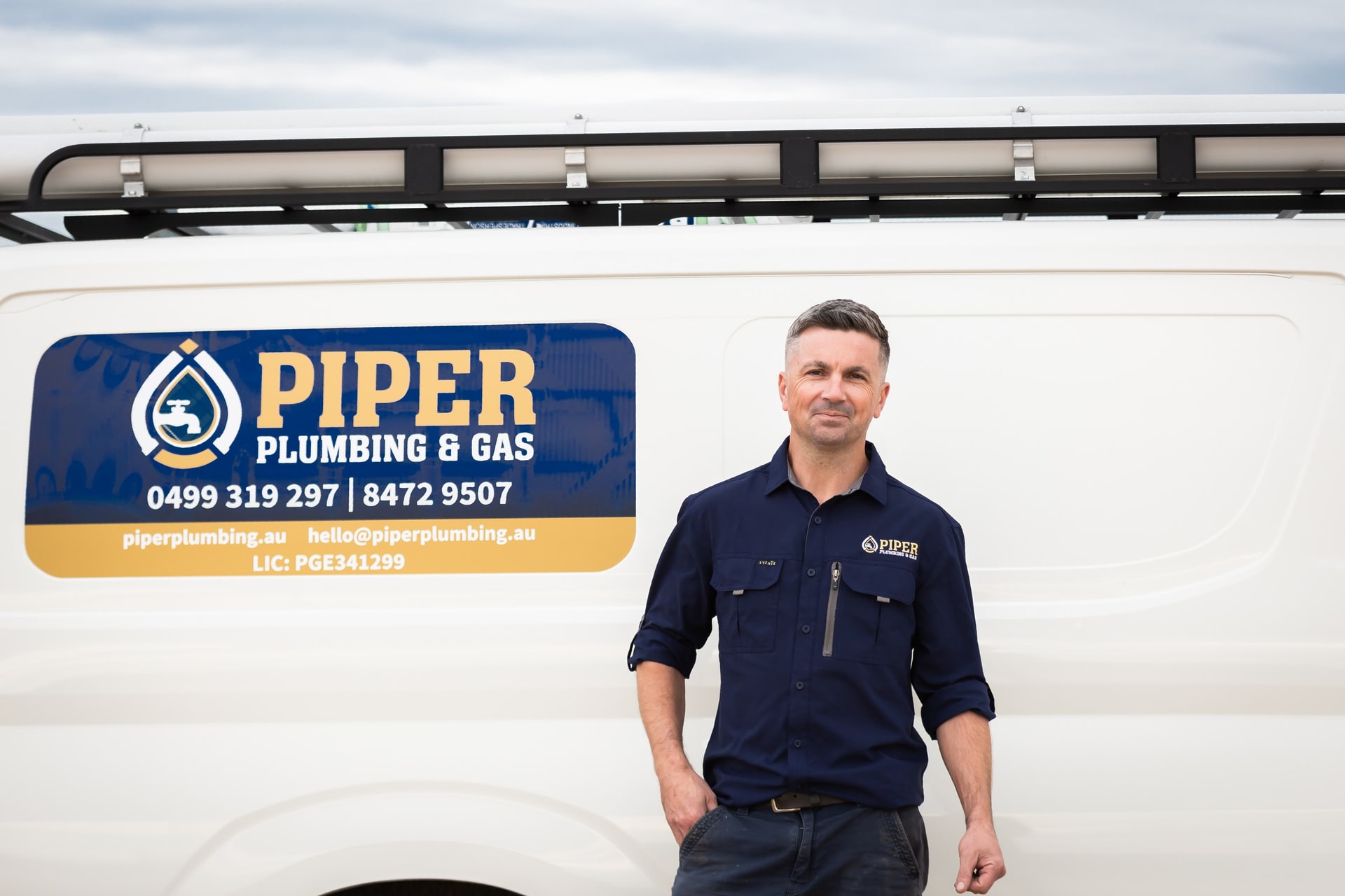 Craig standing beside the Piper van’s signwriting.