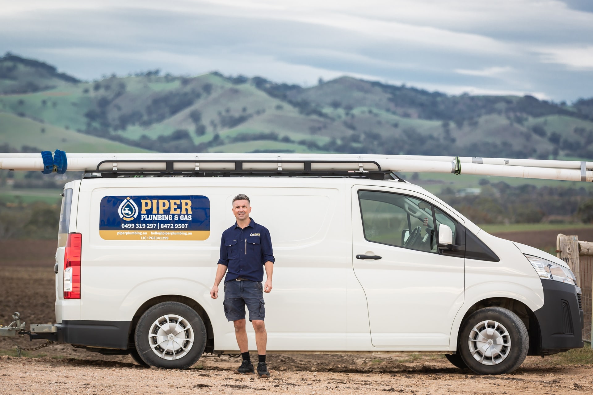 Craig from Piper Plumbing & Gas standing beside the signwritten Piper van in a Barossa paddock.