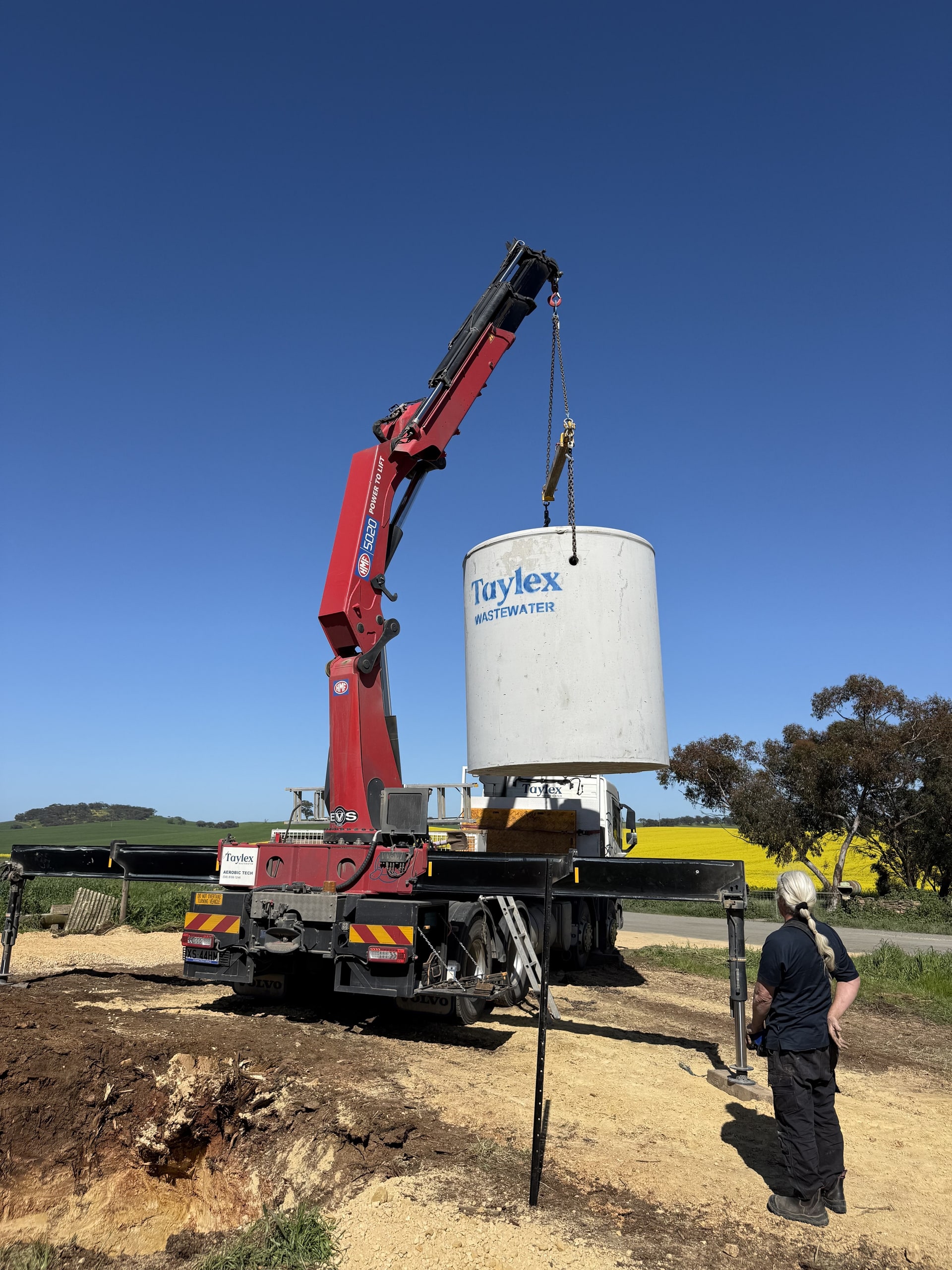 A rainwater tank being lifted into place by a crane.