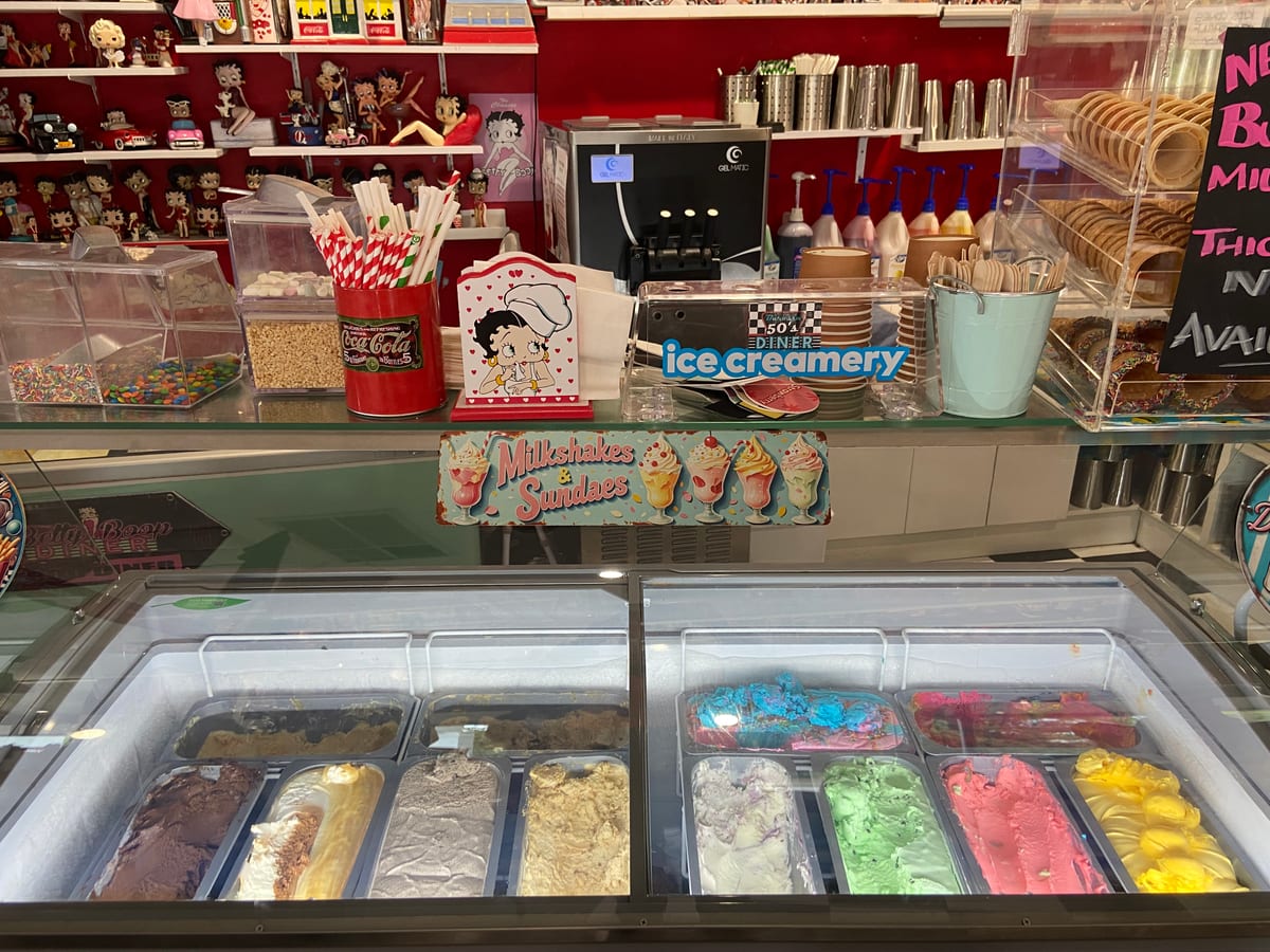The ice creamery counter at Barossa 50’s Diner, with trays of coloured ice cream under glass and retro collectables on the shelves above.