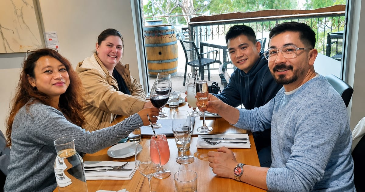 Guests raising a glass together at a winery table during a Barossa Wine Tours day out.