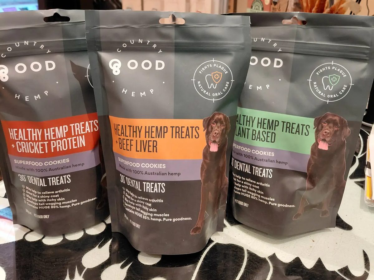 Three bags of hemp dental treats for dogs standing on the shop counter.