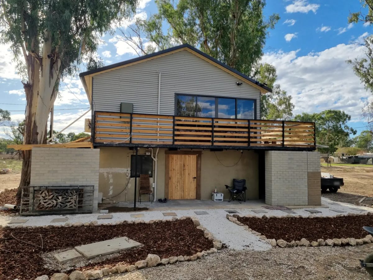 A raised house with a timber balcony, finished outside with new garden beds and a path, one of SA Elite Handyman’s jobs.