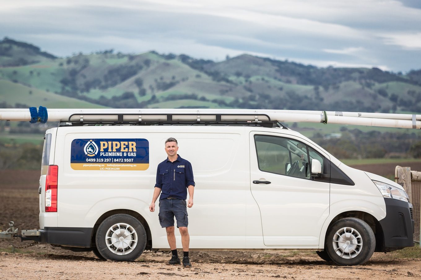 Craig from Piper Plumbing & Gas beside the Piper van in the Barossa hills